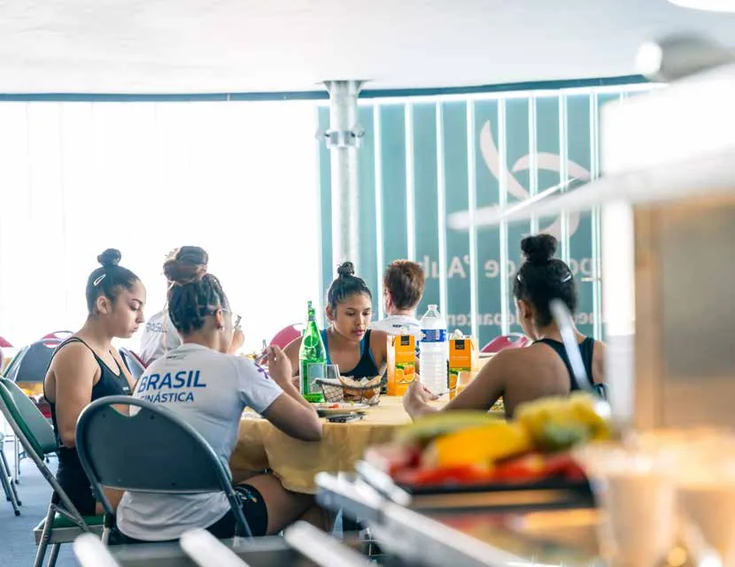 Des sportives attablées au restaurant du Centre sportif de l’Aube, un buffet de fruits au premier plan
