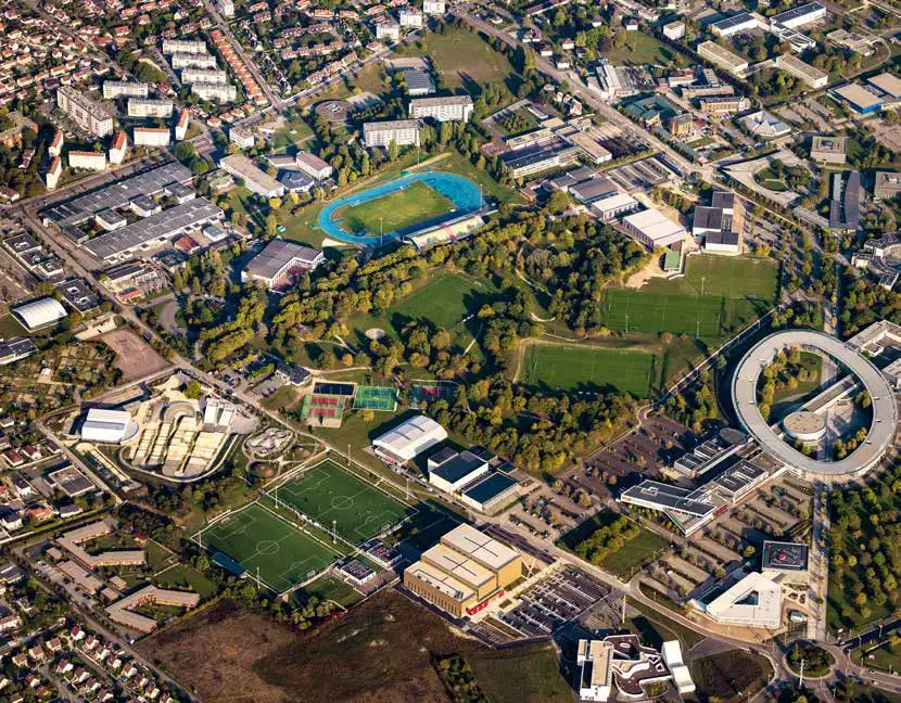 Vue aérienne du quartier du Centre sportif de l’Aube à Troyes : stade d’athlétisme, terrains de football, salles de sport et bâtiments voisins