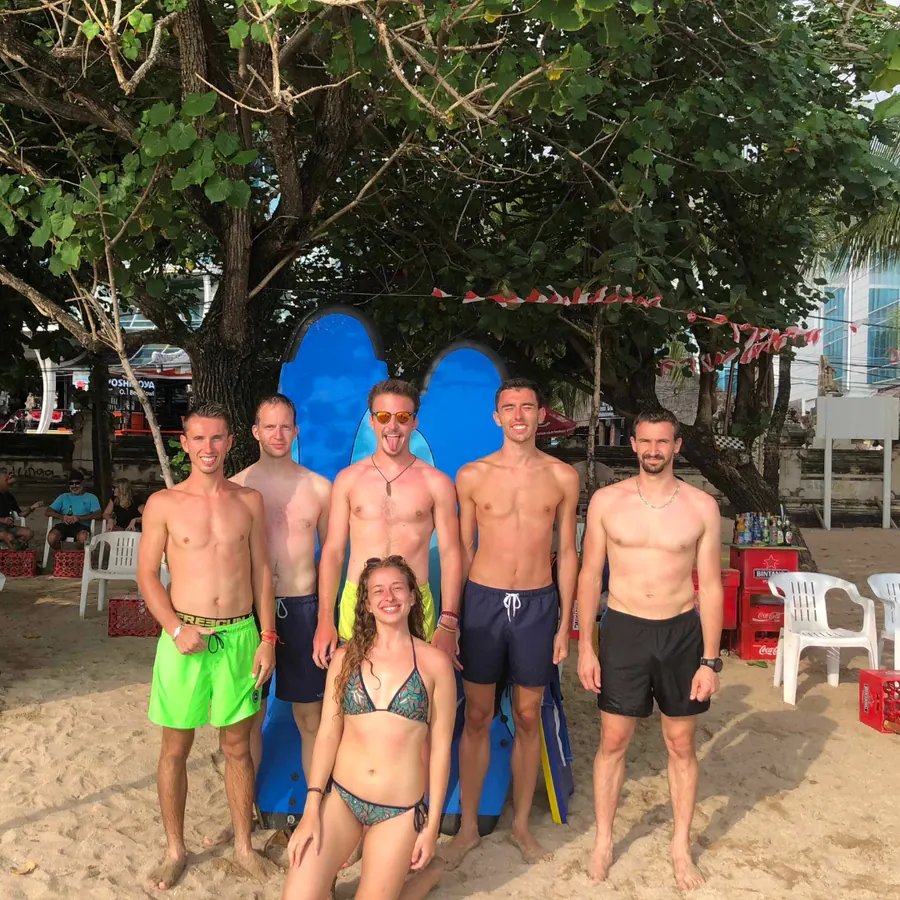 Le groupe en maillot de bain sur une plage de Bali, planches de surf en arrière-plan
