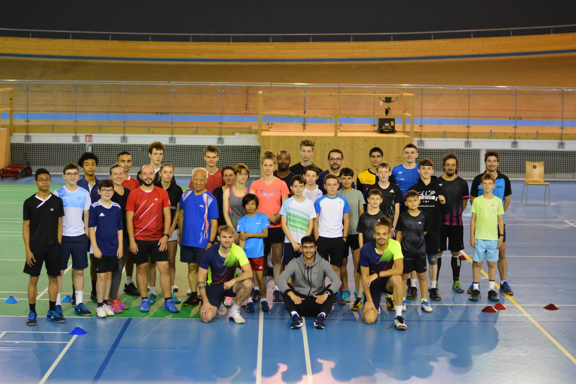 Les stagiaires et les coachs d’une session de stage Fuzions réunis sur le terrain, debout, à genoux et assis